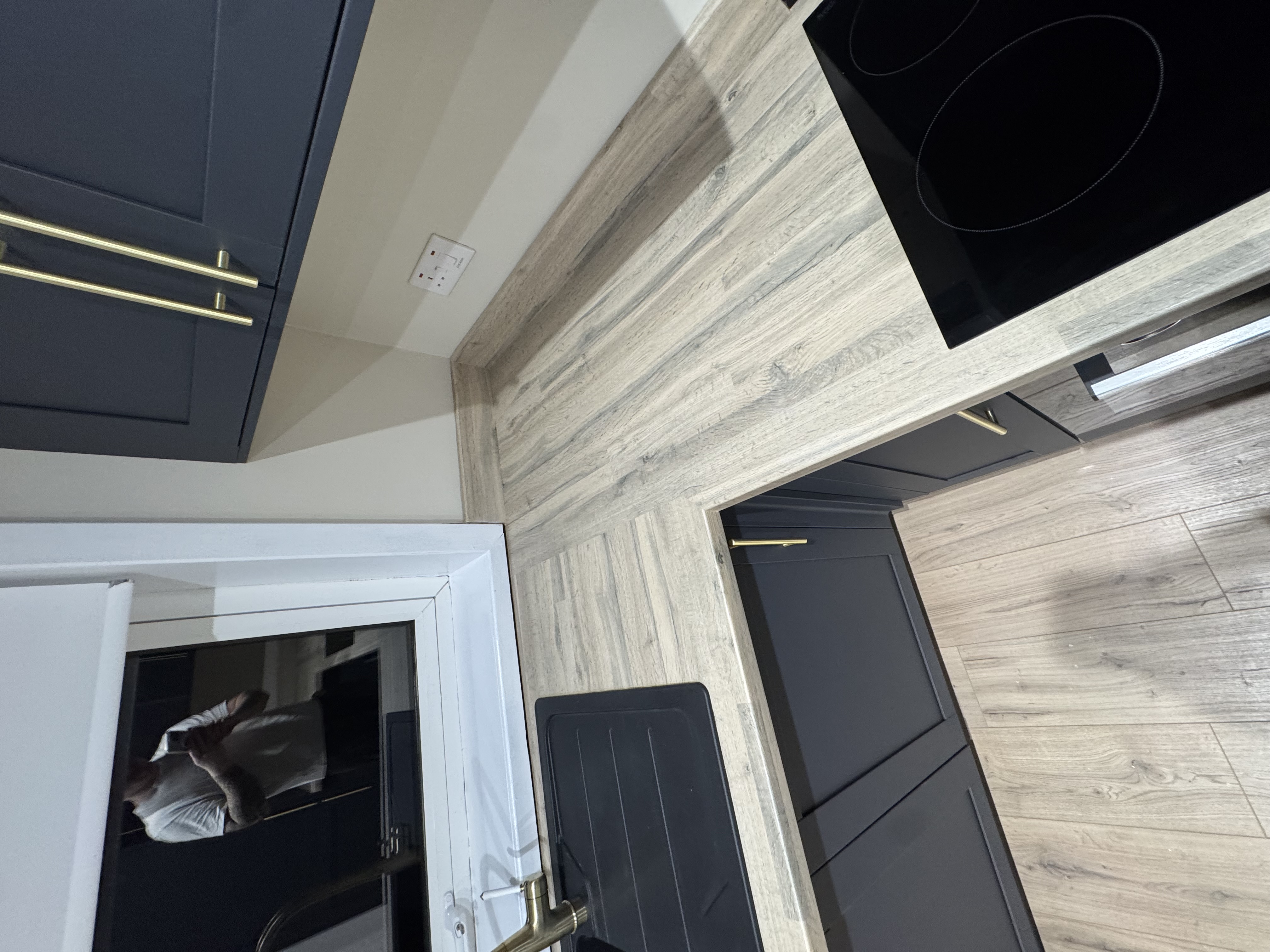 Navy kitchen with wood-effect flooring and glazed door