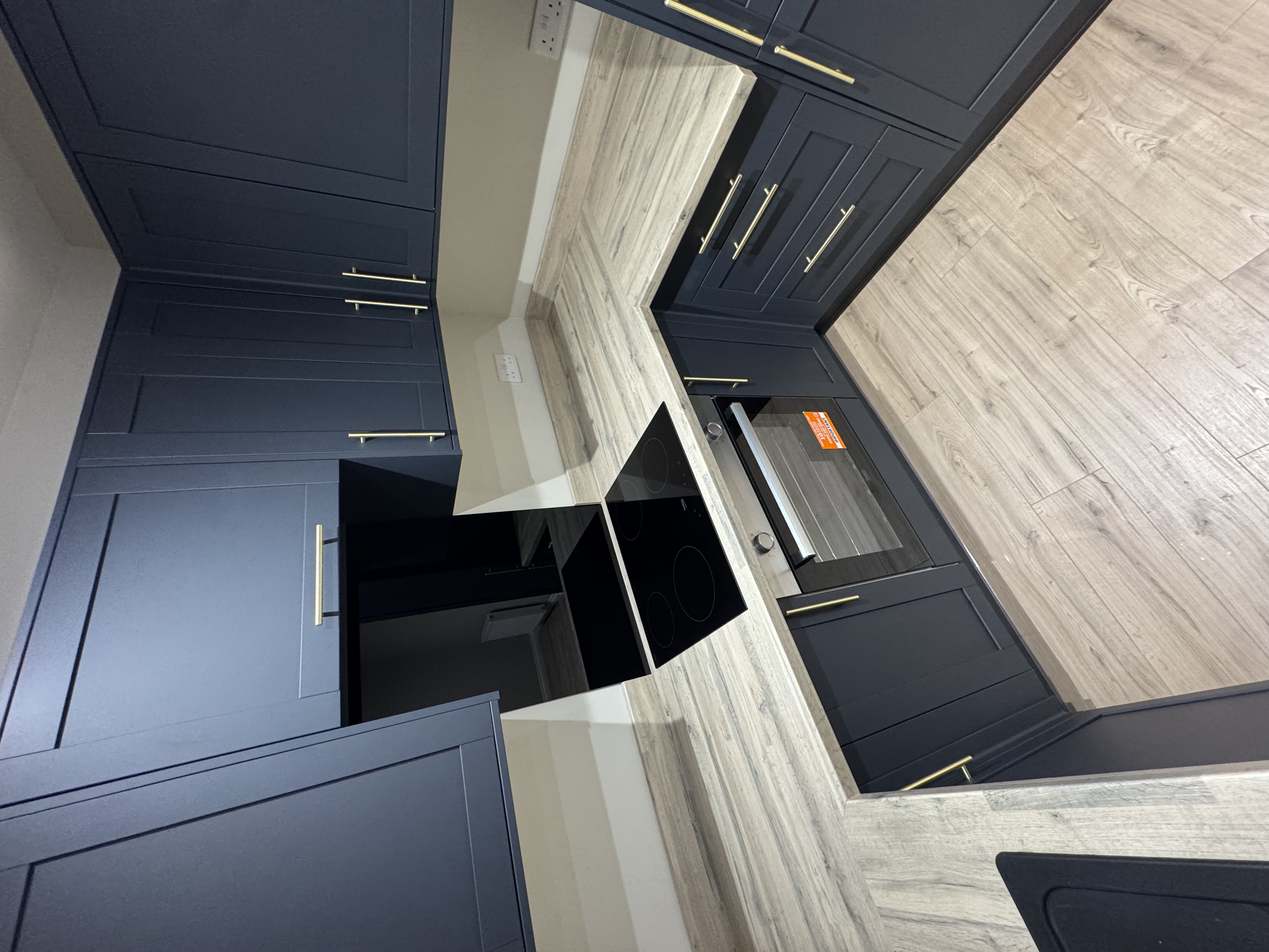Navy kitchen with induction hob and gold handles