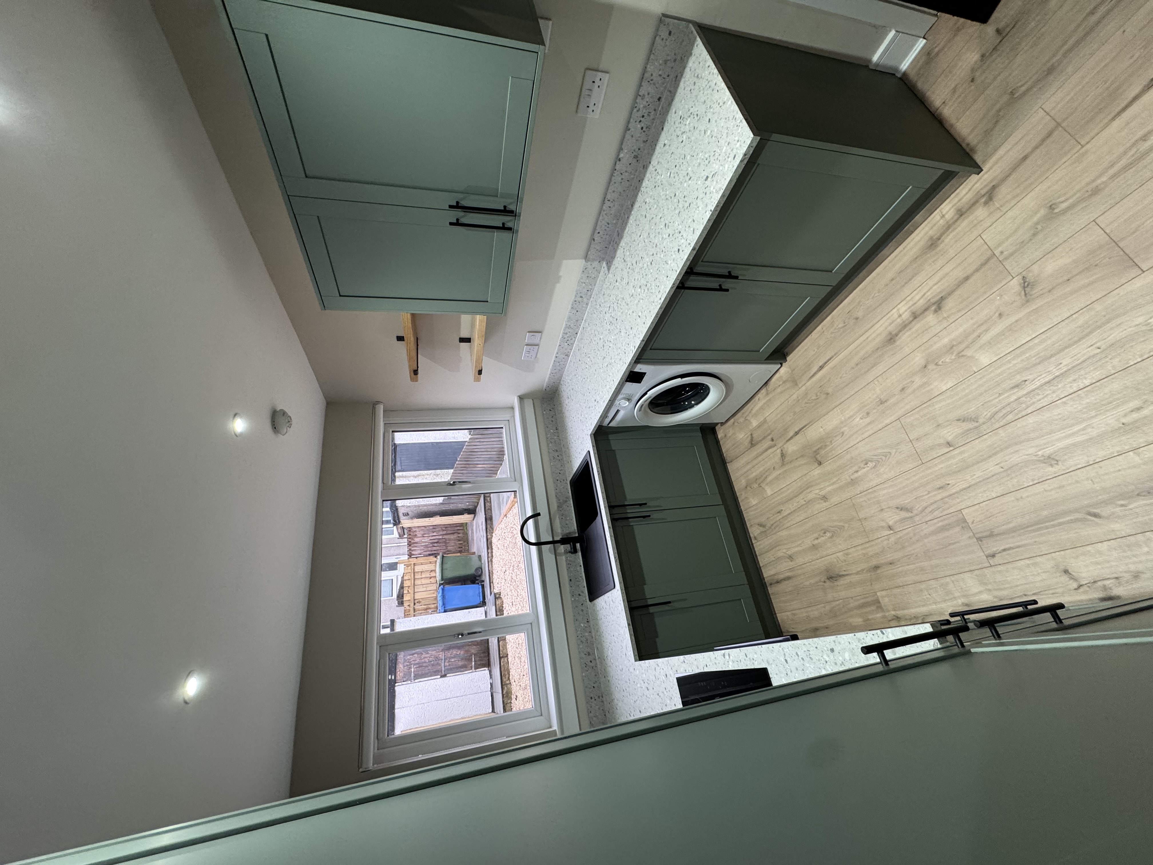 Sage green kitchen with integrated appliances
